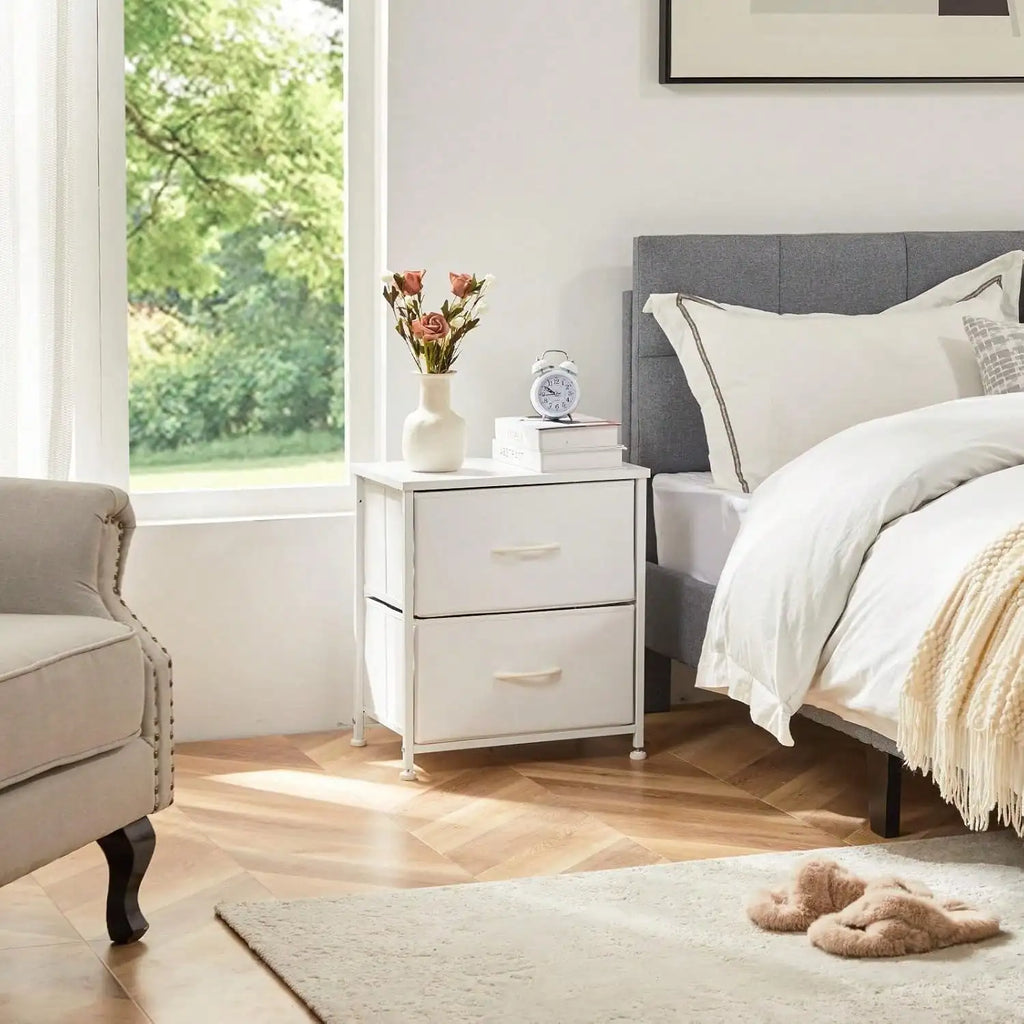 Kaia white nightstand with two drawers beside a bed